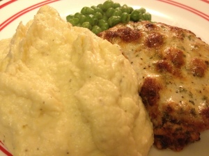 Parmesan crusted pork chops, mashed cauliflower, and peas